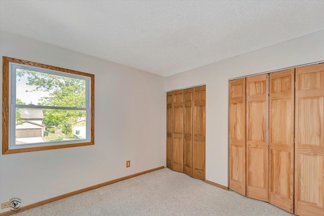 13706 W Cedarbend Dr, Homer Glen, IL 60491 - unfurnished bedroom featuring two closets, light colored carpet, and a textured ceiling