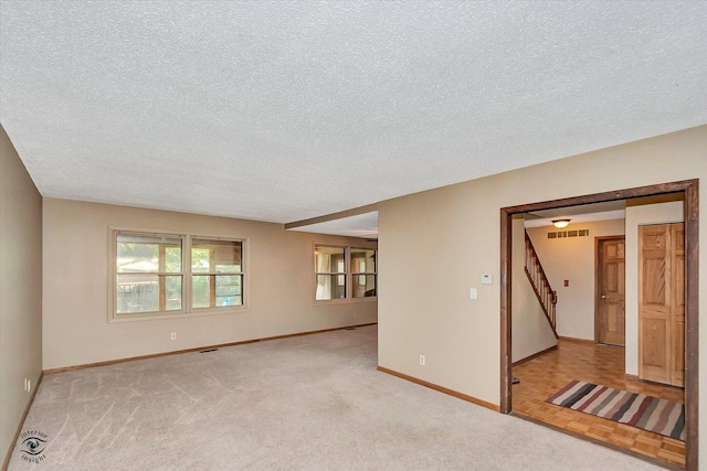 13706 W Cedarbend Dr, Homer Glen, IL 60491 - empty room with a textured ceiling, stairs, and light carpet