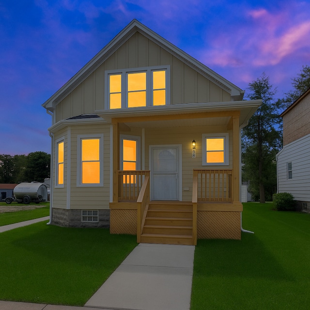 7825 S St Lawrence Ave, Chicago, IL 60619 - bungalow featuring board and batten siding, covered porch, and a front lawn