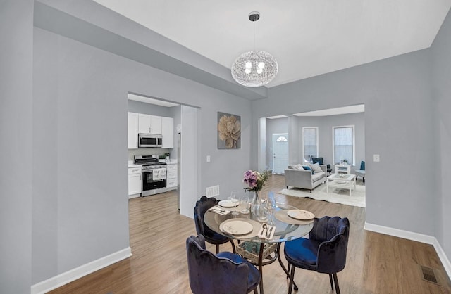 7825 S St Lawrence Ave, Chicago, IL 60619 - dining room featuring a chandelier and light wood-type flooring