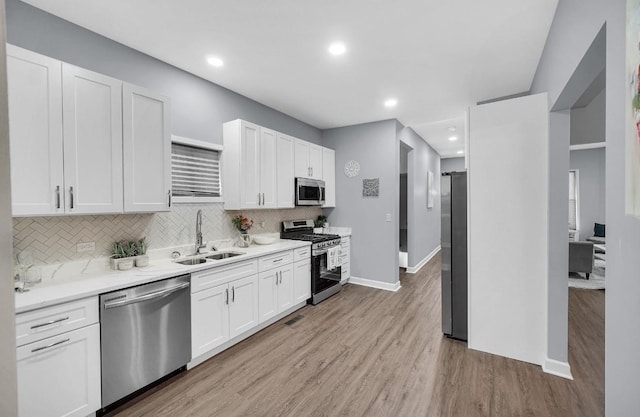 7825 S St Lawrence Ave, Chicago, IL 60619 - kitchen with stainless steel appliances, white cabinets, backsplash, light wood-type flooring, and recessed lighting