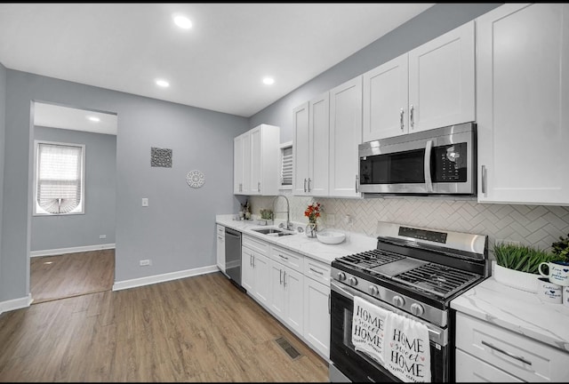 7825 S St Lawrence Ave, Chicago, IL 60619 - kitchen with stainless steel appliances, white cabinetry, backsplash, and recessed lighting