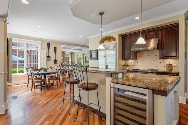 320 Vista Dr, Wilmette, IL 60091 - kitchen featuring wine cooler, under cabinet range hood, stainless steel built in refrigerator, crown molding, and light wood-style floors