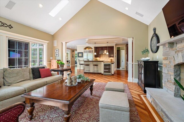 320 Vista Dr, Wilmette, IL 60091 - living area featuring decorative columns, beverage cooler, arched walkways, a skylight, and high vaulted ceiling