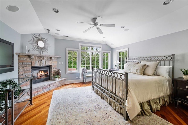 320 Vista Dr, Wilmette, IL 60091 - bedroom with lofted ceiling, multiple windows, a stone fireplace, wood finished floors, and ceiling fan