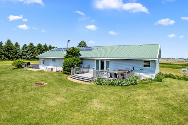 2365 Richardson Rd, West Brooklyn, IL 61378 - rear view of house featuring a yard, a deck, an outdoor fire pit, metal roof, and solar panels