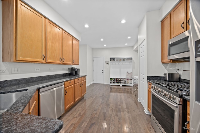 7015 Clearwater Dr Unit 7015, Plainfield, IL 60586 - kitchen with appliances with stainless steel finishes, dark wood-style floors, recessed lighting, dark stone countertops, and brown cabinetry