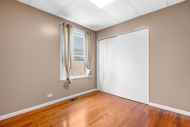 3408 S 58th Ave, Cicero, IL 60804 - unfurnished bedroom with wood finished floors, a closet, and a drop ceiling