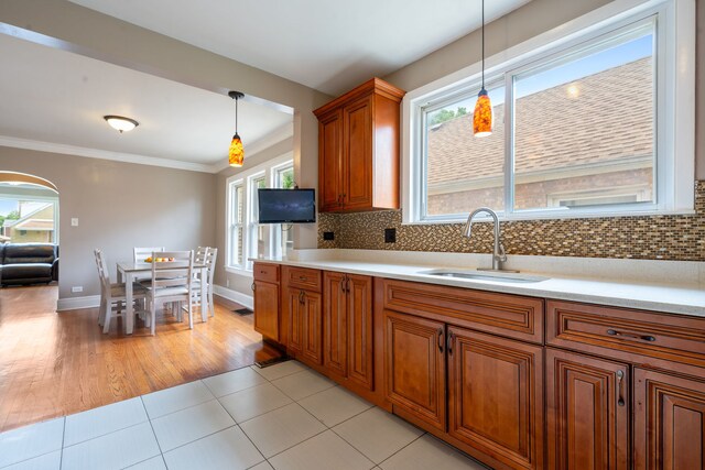 3408 S 58th Ave, Cicero, IL 60804 - kitchen with brown cabinets, light countertops, hanging light fixtures, arched walkways, and ornamental molding