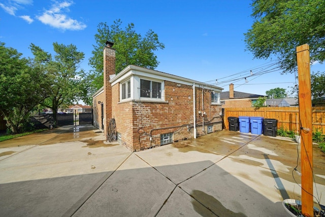 4014 W 77th Pl, Chicago, IL 60652 - rear view of property with brick siding, a patio area, a chimney, and a gate