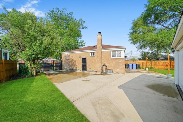 4014 W 77th Pl, Chicago, IL 60652 - rear view of house featuring brick siding, a patio, driveway, a chimney, and a gate