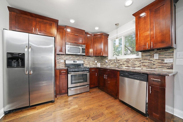4014 W 77th Pl, Chicago, IL 60652 - kitchen featuring appliances with stainless steel finishes, light wood-style flooring, dark stone counters, a sink, and recessed lighting