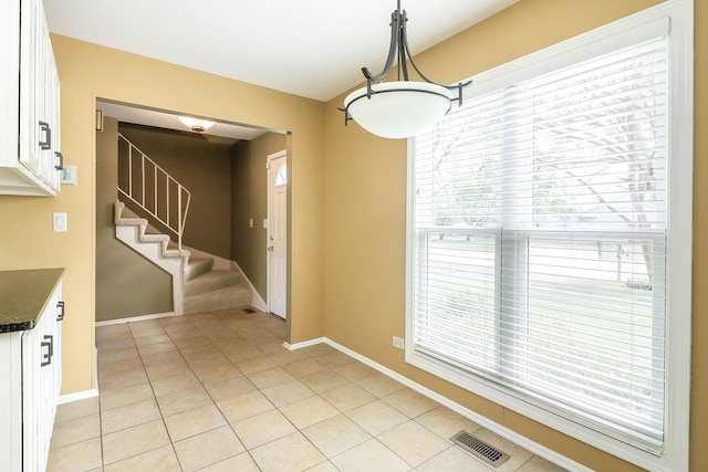 736 73rd St Unit 0, Downers Grove, IL 60516 - unfurnished dining area featuring light tile patterned flooring, healthy amount of natural light, and stairs