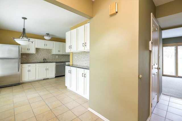 736 73rd St Unit 0, Downers Grove, IL 60516 - kitchen with appliances with stainless steel finishes, dark countertops, light tile patterned floors, backsplash, and white cabinets