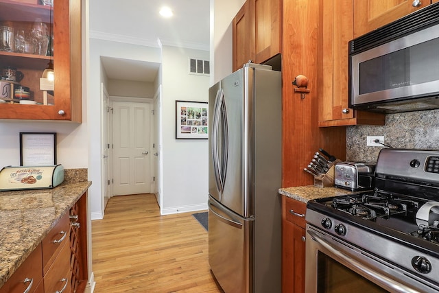 1355 W Washington Blvd Unit 4A, Chicago, IL 60607 - kitchen with appliances with stainless steel finishes, ornamental molding, brown cabinets, tasteful backsplash, and light wood-style floors