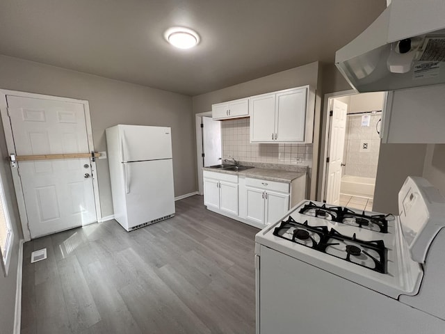 920 S Mcalister Ave, Waukegan, IL 60085 - kitchen with white appliances, ventilation hood, wood finished floors, white cabinetry, and light countertops