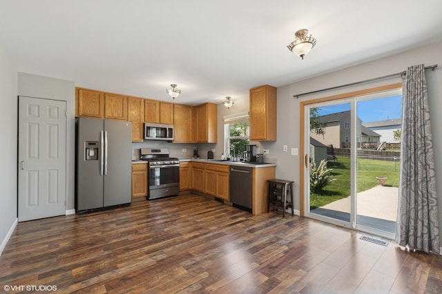 261 E Camden Ln, Round Lake Beach, IL 60073 - kitchen with appliances with stainless steel finishes, dark wood finished floors, light countertops, a sink, and baseboards