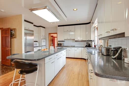 kitchen featuring white microwave, dark countertops, light wood-style floors, white cabinetry, and recessed lighting