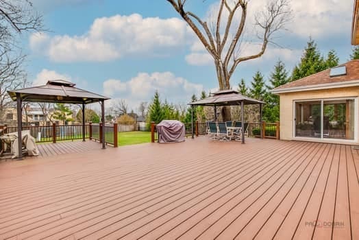 wooden terrace with a gazebo and outdoor dining area