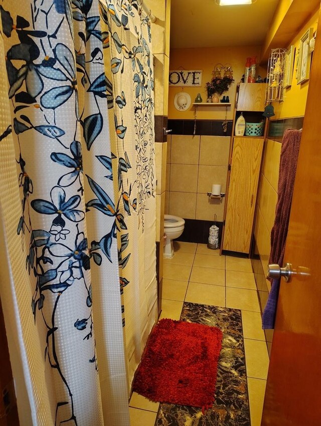 2240 W 50th Pl, Chicago, IL 60609 - full bath featuring toilet, tile walls, tile patterned flooring, wainscoting, and curtained shower