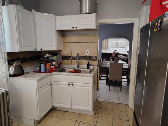 2240 W 50th Pl, Chicago, IL 60609 - kitchen with freestanding refrigerator, a sink, radiator heating unit, white cabinets, and light countertops