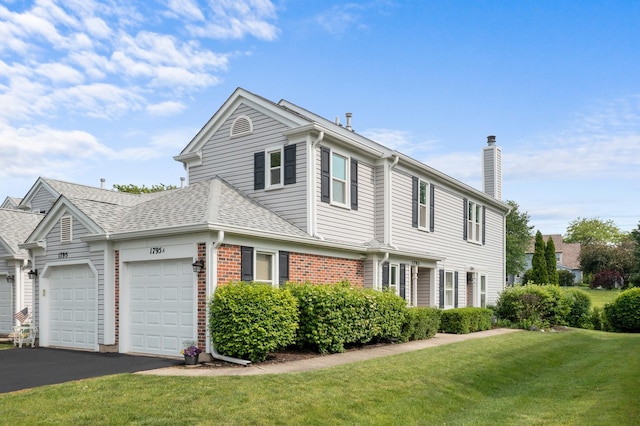1795 Vermont Dr Unit A, Elk Grove Village, IL 60007 - view of front of home featuring a chimney, a garage, a front lawn, driveway, and roof with shingles
