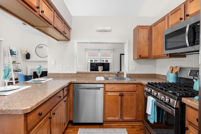 1795 Vermont Dr Unit A, Elk Grove Village, IL 60007 - kitchen featuring stainless steel appliances, light wood-style floors, brown cabinetry, and a peninsula