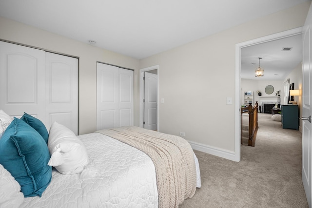 1795 Vermont Dr Unit A, Elk Grove Village, IL 60007 - bedroom featuring light colored carpet, multiple closets, and a fireplace