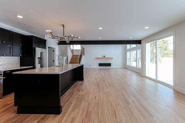 26101 W Forrester Dr, Plainfield, IL 60585 - kitchen featuring stainless steel fridge, dark cabinets, a chandelier, light countertops, and light wood finished floors