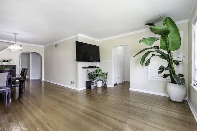 4024 N Overhill Ave, Norridge, IL 60706 - unfurnished living room featuring arched walkways, wood finished floors, a chandelier, and ornamental molding