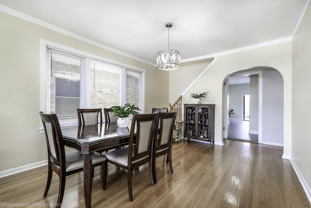 4024 N Overhill Ave, Norridge, IL 60706 - dining area featuring arched walkways, healthy amount of natural light, wood finished floors, a chandelier, and crown molding