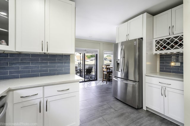 4024 N Overhill Ave, Norridge, IL 60706 - kitchen featuring stainless steel fridge, white cabinets, decorative backsplash, glass insert cabinets, and light stone countertops