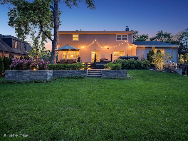 195 N Park Blvd, Glen Ellyn, IL 60137 - back of house at dusk featuring a lawn, a wooden deck, and a chimney