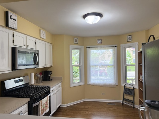 1742 Victor Ter, Gurnee, IL 60031 - kitchen with stainless steel appliances, dark wood finished floors, light countertops, white cabinetry, and baseboards