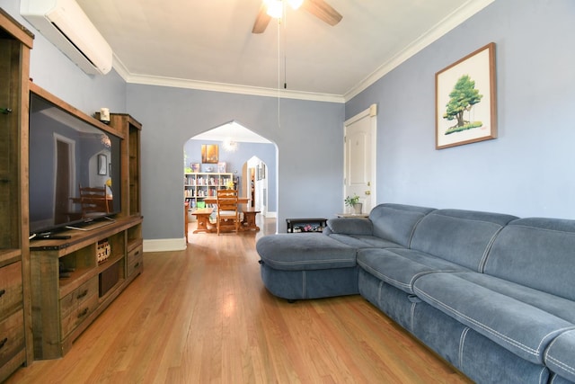 living room with arched walkways, a wall mounted air conditioner, a ceiling fan, light wood-style floors, and crown molding