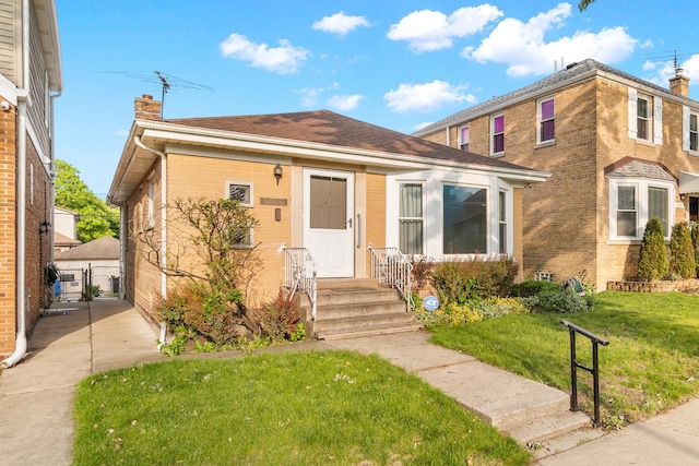 5129 N Normandy Ave, Chicago, IL 60656 - view of front of property featuring a chimney, a front yard, brick siding, a gate, and roof with shingles
