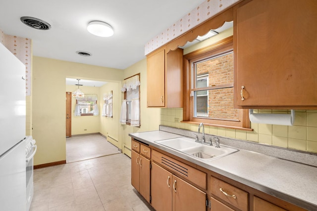 5129 N Normandy Ave, Chicago, IL 60656 - kitchen featuring light countertops, tasteful backsplash, and brown cabinets