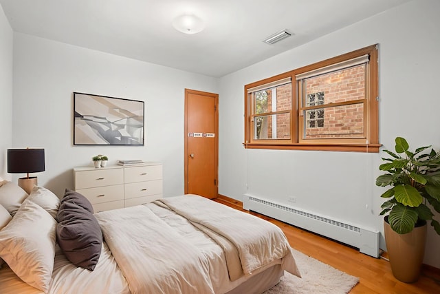 5129 N Normandy Ave, Chicago, IL 60656 - bedroom featuring a baseboard heating unit and wood finished floors