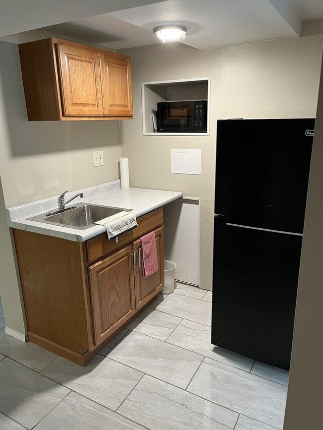 1018 E Oak Ave, La Grange Park, IL 60526 - kitchen featuring black appliances, a sink, light countertops, and brown cabinets