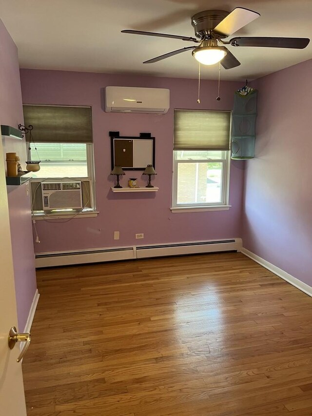 1018 E Oak Ave, La Grange Park, IL 60526 - spare room with a wall unit AC, baseboard heating, wood finished floors, and a ceiling fan