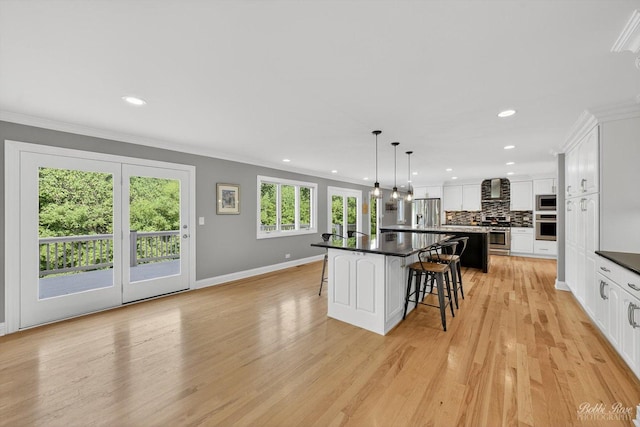 1714 Il Route 173, Spring Grove, IL 60081 - kitchen featuring appliances with stainless steel finishes, wall chimney exhaust hood, a kitchen bar, crown molding, and dark countertops