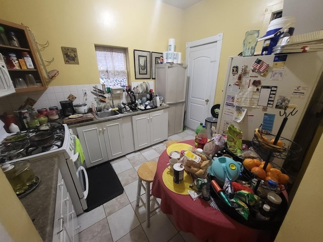 817 N Kolin Ave, Chicago, IL 60651 - kitchen with white appliances, a sink, light tile patterned flooring, and dark countertops