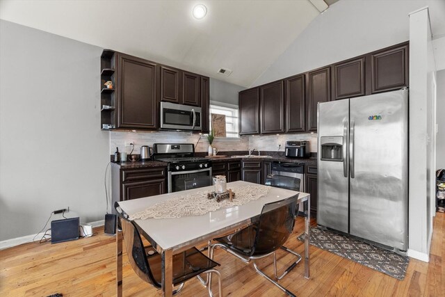 5905 S Indiana Ave, Chicago, IL 60637 - kitchen featuring stainless steel appliances, dark brown cabinetry, lofted ceiling, a sink, and light wood finished floors