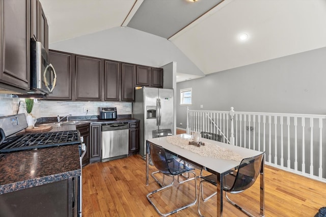 5905 S Indiana Ave, Chicago, IL 60637 - kitchen with stainless steel appliances, lofted ceiling, dark brown cabinets, dark countertops, and light wood-style flooring