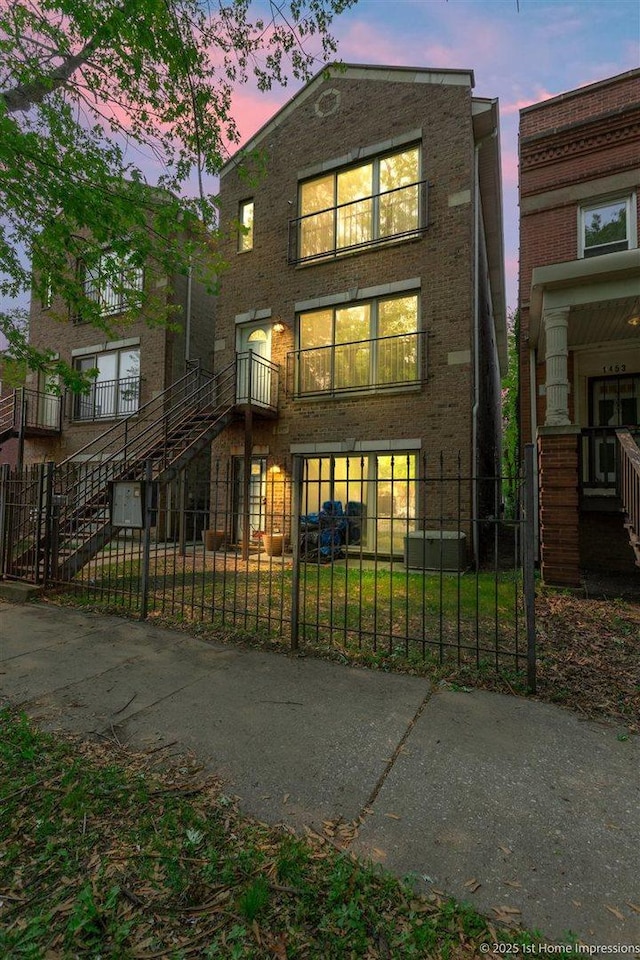1457 E 71st Pl Unit 3, Chicago, IL 60619 - view of front facade featuring stairs, a fenced front yard, brick siding, and a balcony