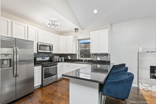1457 E 71st Pl Unit 3, Chicago, IL 60619 - kitchen featuring appliances with stainless steel finishes, a sink, a peninsula, backsplash, and lofted ceiling