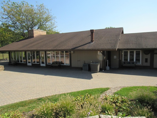 13 Saint Thomas Colony Unit 2, Fox Lake, IL 60020 - rear view of property featuring a chimney, cooling unit, a shingled roof, and a patio