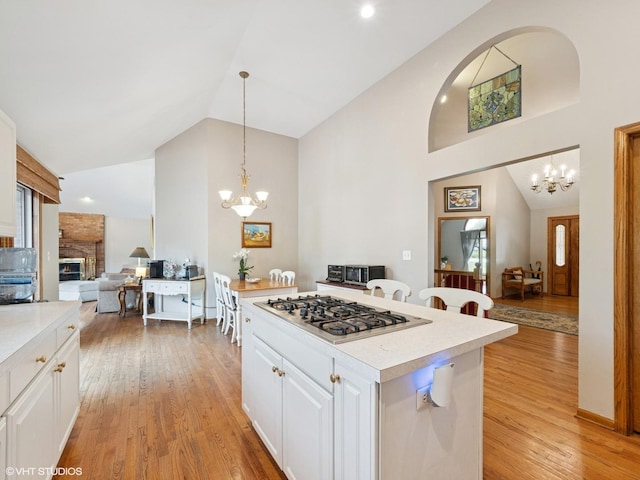 1520 Grant St, Schaumburg, IL 60193 - kitchen with a chandelier, stainless steel gas stovetop, open floor plan, high vaulted ceiling, and light countertops