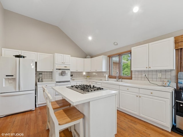 1520 Grant St, Schaumburg, IL 60193 - kitchen with white appliances, light countertops, vaulted ceiling, a center island, and decorative backsplash