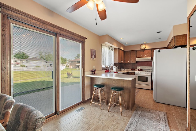 17007 Westwood Ct, Orland Hills, IL 60487 - kitchen featuring gas range gas stove, freestanding refrigerator, under cabinet range hood, a peninsula, and a ceiling fan